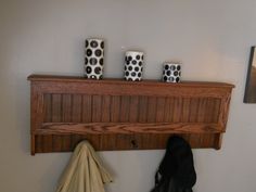 a coat rack with three black and white vases on it, hanging from the wall