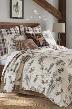 the bed is made up with deer and plaid comforter sets on top of it