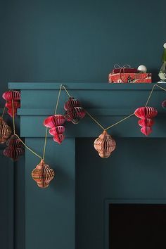 a fireplace mantel with paper lanterns hanging from it