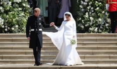 the bride and groom are standing on steps in front of an official guard at their wedding