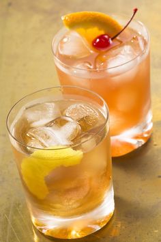 two glasses filled with drinks sitting on top of a table