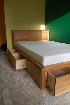 a bed with two drawers underneath it in a green room next to a white carpeted floor