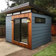 a small blue shed sitting on top of a lush green field