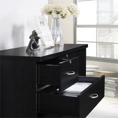 a black desk with two drawers and some flowers