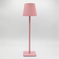 a pink floor lamp on a white surface with a light shade over the lampshade