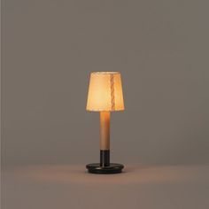 a lamp that is on top of a black stand with a white light inside it