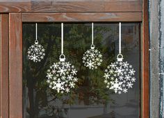 three snowflakes hanging from the side of a window