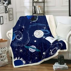 a living room with a white couch and blue blanket on top of the sofa is an image of outer space