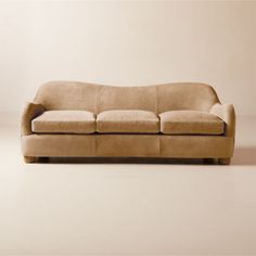 a tan couch sitting on top of a white floor