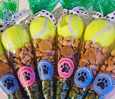 four tennis balls are wrapped in plastic bags with dog paw prints on the top and bottom