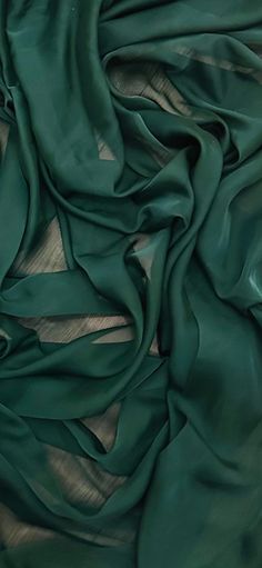 green silk fabric on top of a wooden table