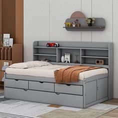 a bedroom with a bed, dresser and shelves on the wall next to each other