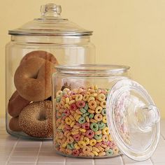 two glass jars filled with cereal and pretzels