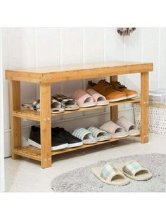 a wooden shoe rack filled with shoes on top of a white floor next to a rug