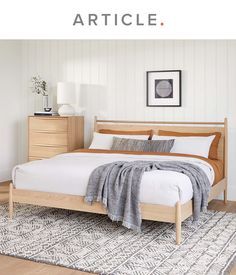 a bedroom with white walls and wood furniture