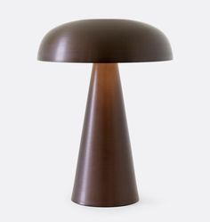 a brown table lamp sitting on top of a white wall