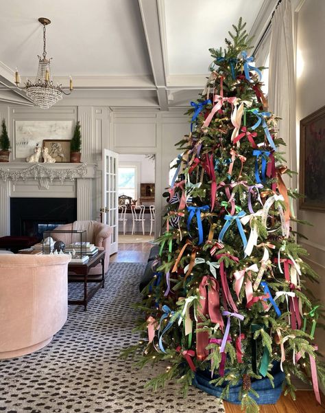 a decorated christmas tree in the middle of a living room with white walls and ceiling