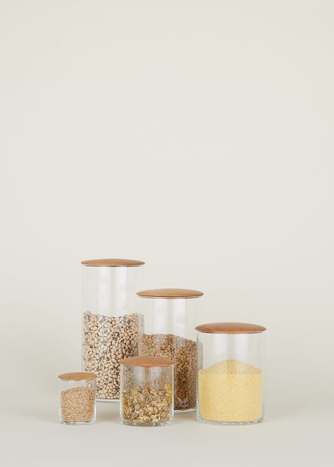 EVERYTHING IN ITS PLACE Simple glass containers paired with either oil rubbed, turned oak. These storage containers are perfect for storing dry goods in the kitchen, bathroom essentials, or equally useful as small collection containers or terrariums. Use these in a grouping for an interesting addition of verticality to any space. MINI, 2.5 x 3" EXTRA SMALL, 3.5 x 4" SMALL, 4.5 x 6" MEDIUM, 4.5 x 8" LARGE, 4.5 x 10" DETAILS: Materials: Glass + Oak Care: Glass is dishwasher safe, Oak lids should b Storing Dry Goods, Cute Terrarium, Kitchen Storage Canisters, Brooms And Brushes, Glass Storage Containers, Tea Jar, Kitchen Utilities, Beautiful Storage, Storage Canisters