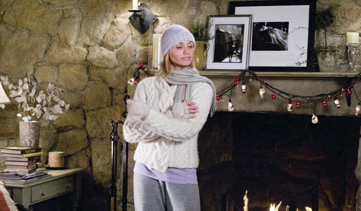 a woman standing in front of a fire place