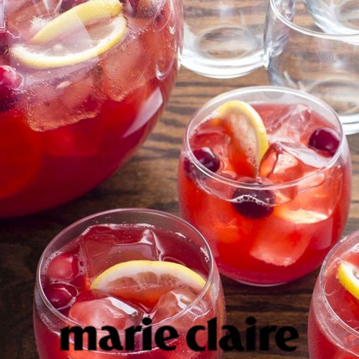 three glasses filled with red liquid and lemon wedges on top of a wooden table