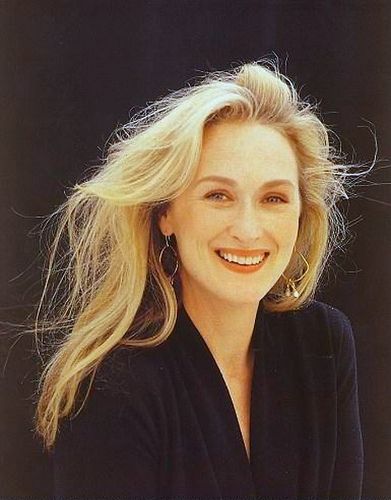 a woman with long blonde hair smiling at the camera