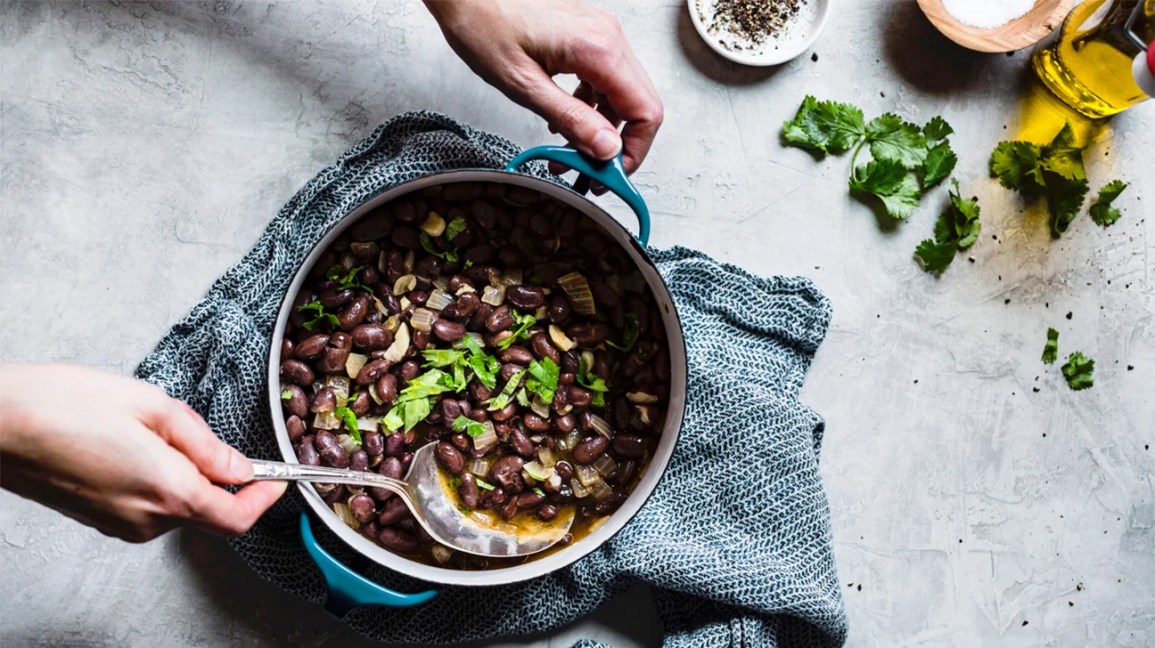 A pot of beans being served.