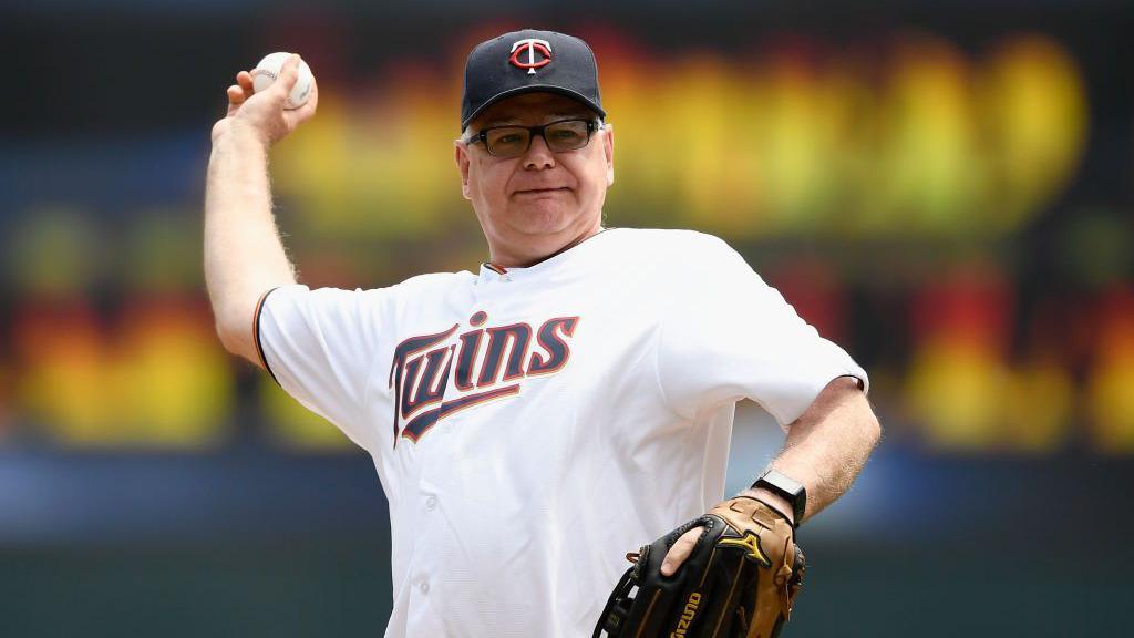 Tim Walz throwing a ball at a baseball game