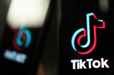 close up of two phones displaying the tiktok logo screen