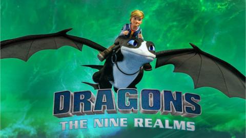 Dragons: The Nine Realms is a 3D animated show, a young blonde boy rides on top of a black and white dragon with large blue eyes.