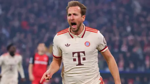 Harry Kane of Bayern Munich celebrates after scoring in the Champions League last 16 first leg match against Bayer Leverkusen.