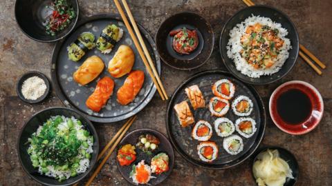 Plates of Japanese food on plates with chop sticks from a high angle.