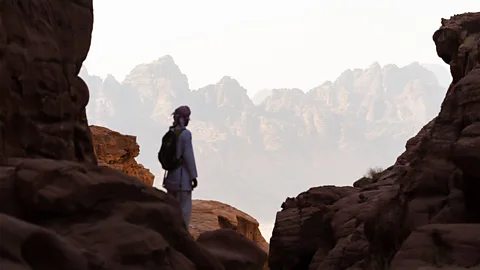 Man on a rocky outlook looking at mountains in the distance (Credit: Anthon Jackson)