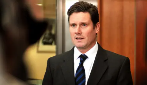 Keir Starmer in suit and blue stripped tie in 2010