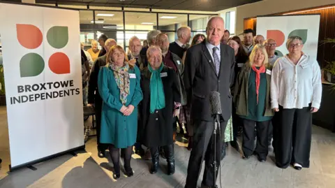 A group of Broxtowe Borough Councillors standing next to a sign that says 'Broxtowe Independents'