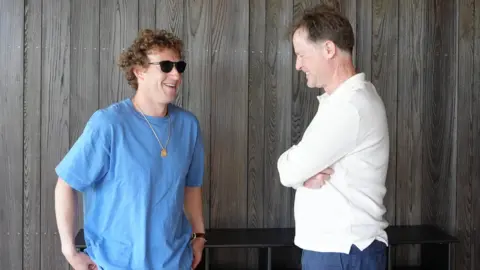 Mark Zuckerberg, chief executive of Meta, in a blue T-shirt and sunglasses, with Sir Nick Clegg in a white long-sleeve T-shirt, both laughing