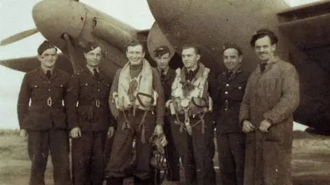 Black and white photo of the Polish Air Force's 307 Squadron at RAF Exeter during World War Two. They are stood in front of a plane.