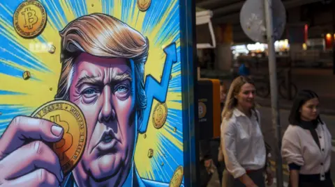 Cartoon image of US President-elect Donald Trump holding a Bitcoin token displayed at a Coinhero store in Hong Kong.