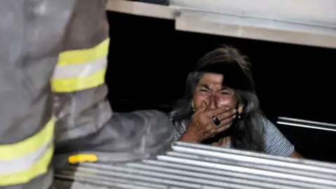 A woman is rescued from a trapped elevator