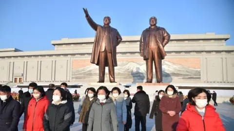 In this photo taken on February 16, 2022, people visit the bronze statues of former President Kim Il Sung 