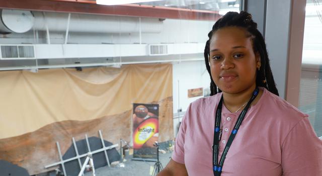 Jasmine Cameron poses in the viewing gallery of the In-Situ Instruments Laboratory at JPL