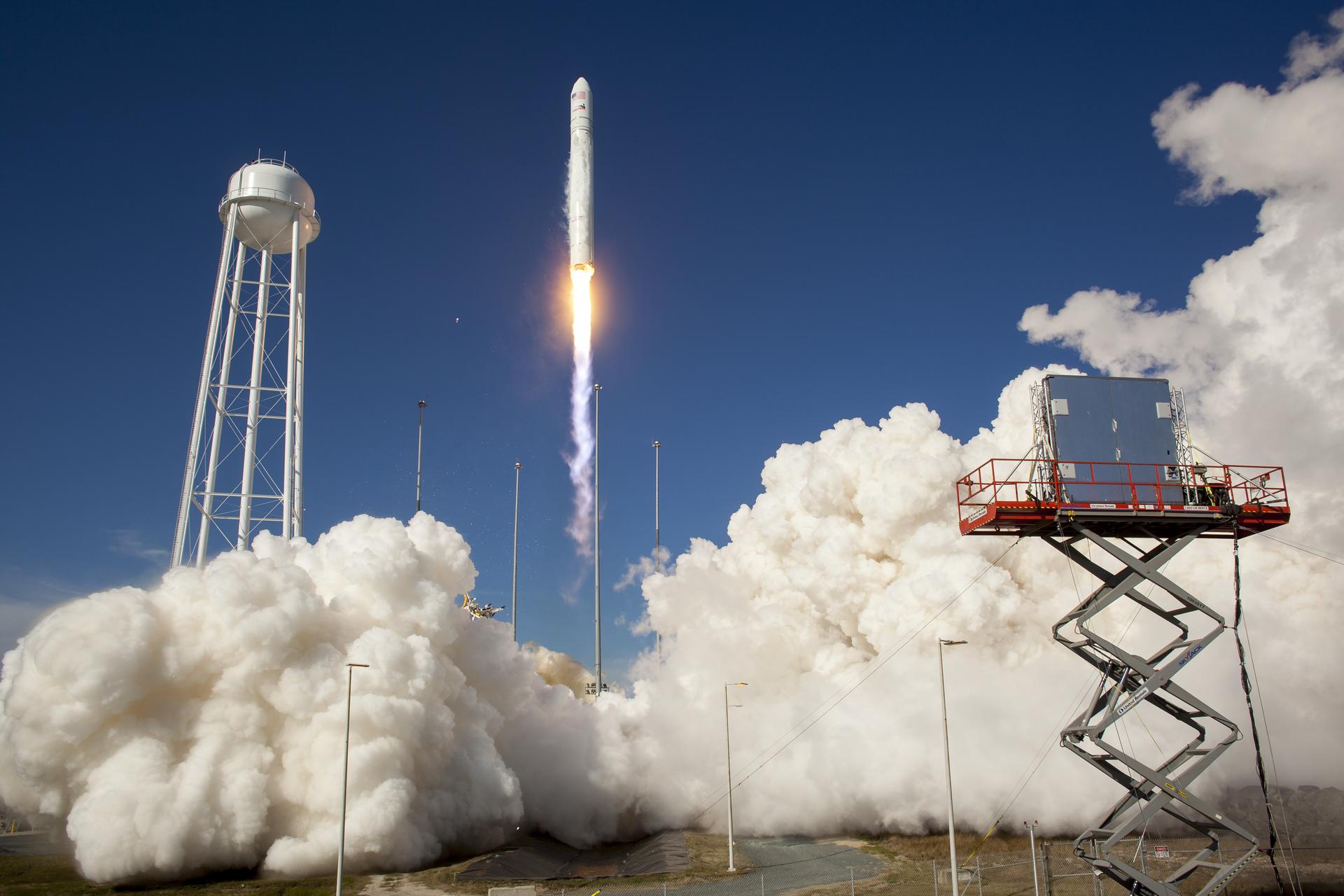 The Antares rocket lifting off Pad 0A, a plume of white smoke underneath.