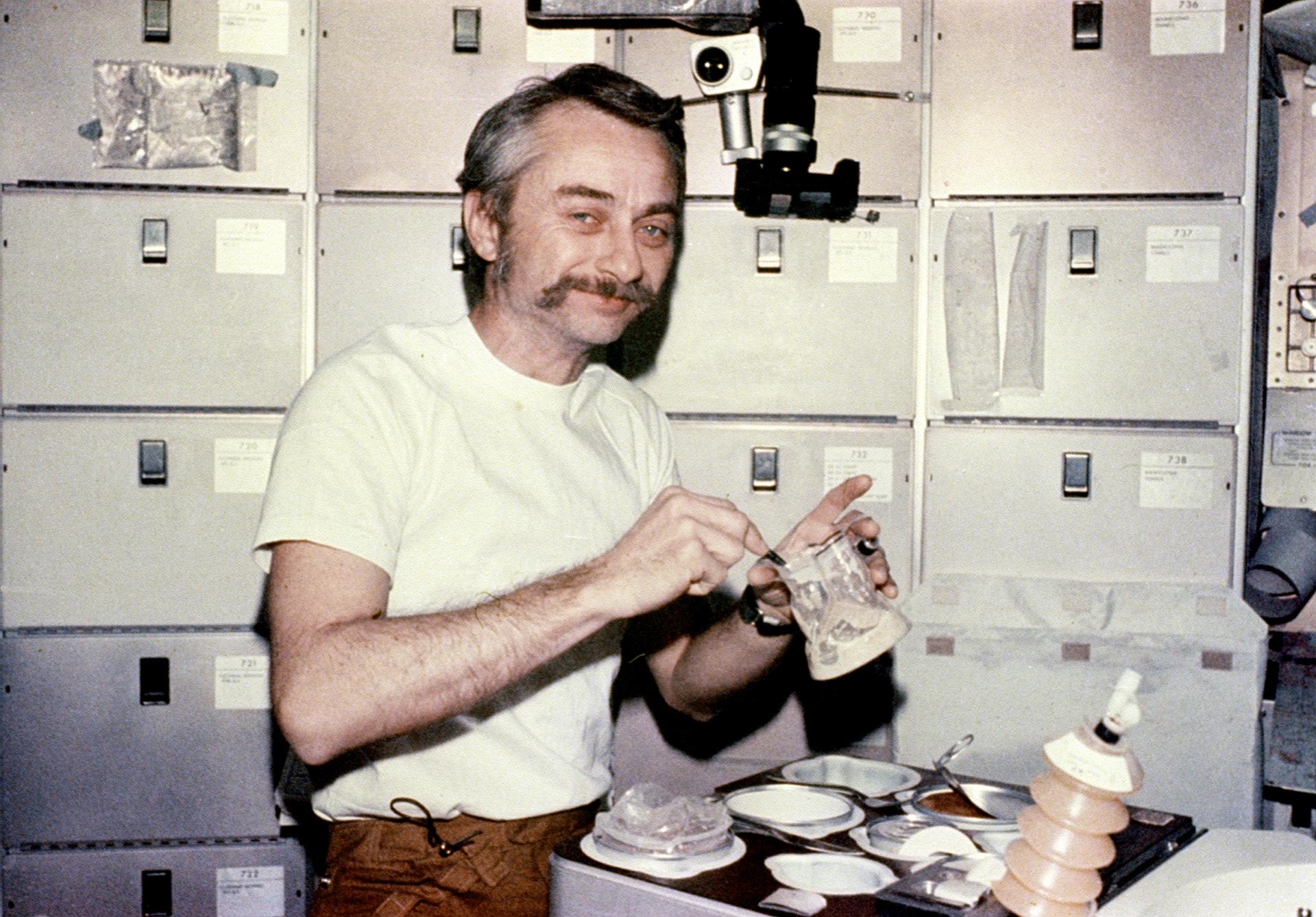 Astronaut Owen Garriott enjoys his meal in Skylab's ward room.