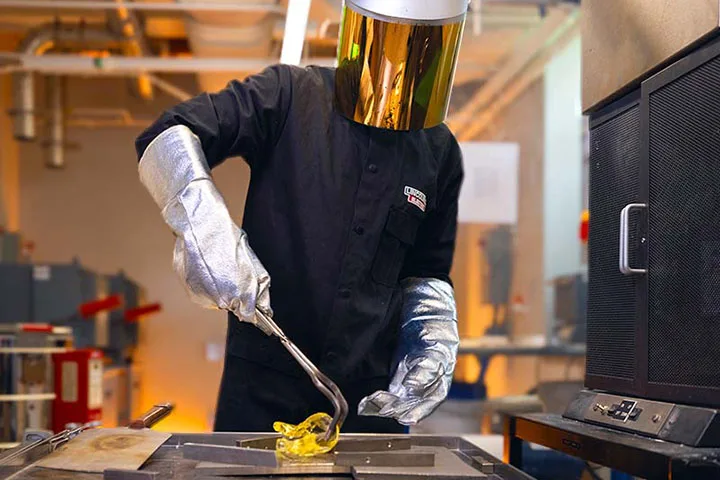 Photo of student wearing protective gear working with yellow material