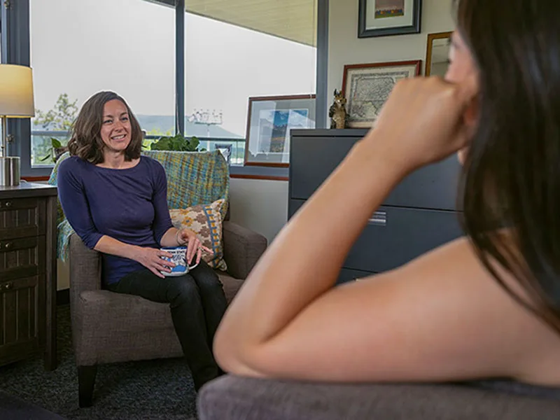 A student and a staff member talking inside an office