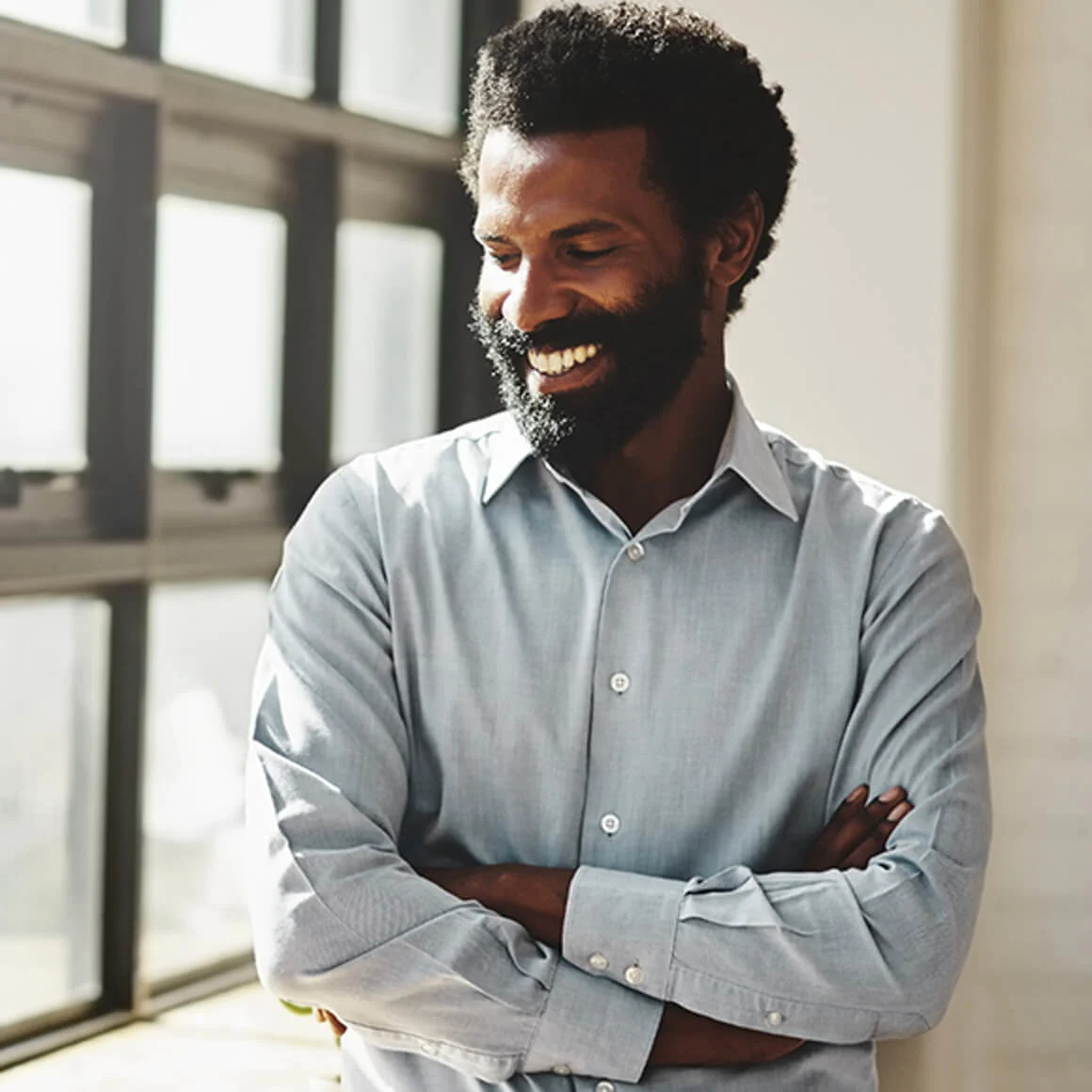 Man smiling next to window