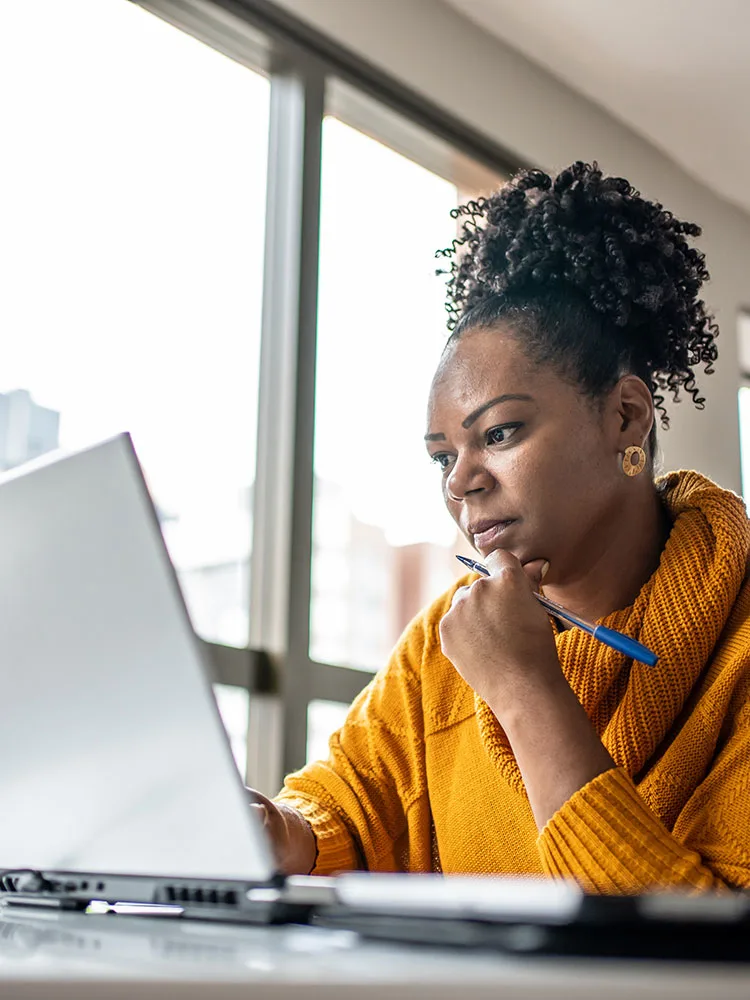 Woman on laptop next to window