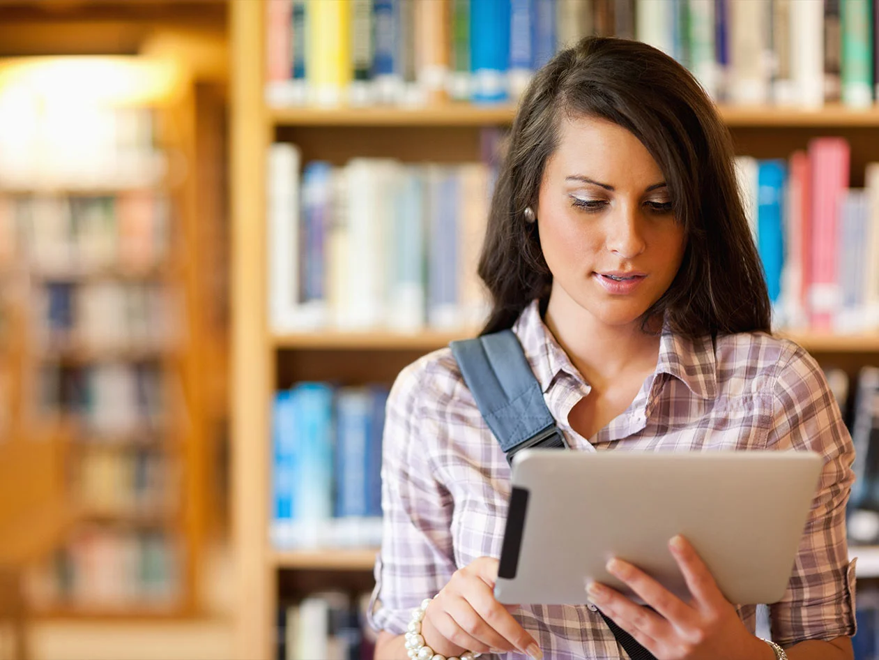 Woman in library with a tablet