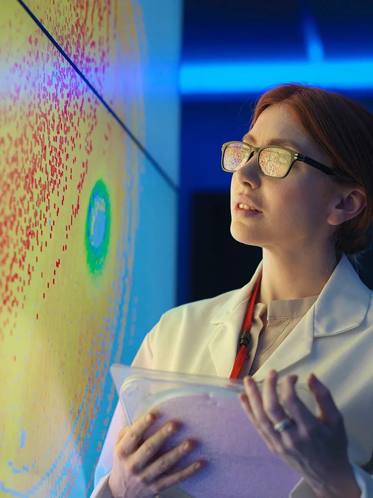 Researcher looking at image on screen and holding device