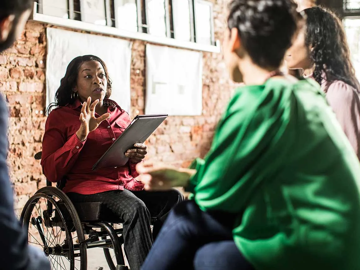 Woman in a wheelchair leading a meeting