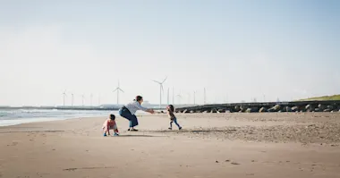 family in a beach with windmilss